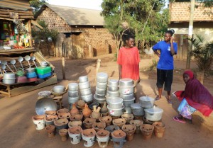 Miljonstaden Kampala växer snabbt ut åt alla håll och här kan man bokstavligen se medelklassens tillväxt genom de välbyggda och stabila tegelhus som byggs, inte stora men rejäla.  På ett litet torg här i förorten Kumunana säljer unga kvinnor köksredskap, inklusive de koleldade minispisarna i keramik. (Foto: Daniel van der Blij)
