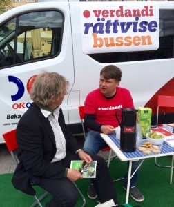 Magnus Bååth är projektledare för Rättvisebuss-turnén. Här sitter han i samtal med en besökare på Medborgarplatsen i Stockholm.
